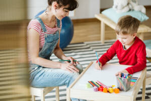 kid drawing with occupational therapist