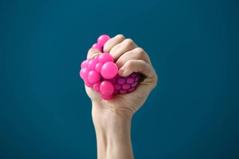 squeezing a pink stress relief ball-min stress relief tips for college students