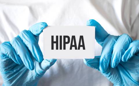 HIPAA doctor hands holding white sign with HIPAA on it