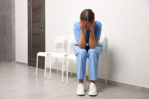 what is nurse burnout? Exhausted doctor sitting on chair in hospital, space for text
