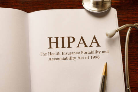 Page with HIPAA (The Health Insurance Portability and Accountability Act of 1996) on the table with stethoscope, medical concept HIPAA in a book