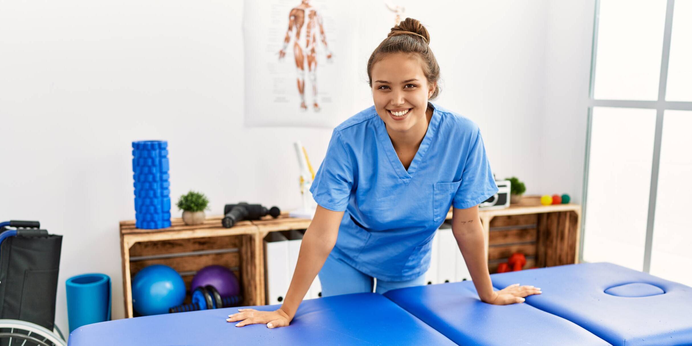 Young PTA working in St. Louis Young beautiful hispanic woman physiotherapist smiling confident standing at rehab clinic